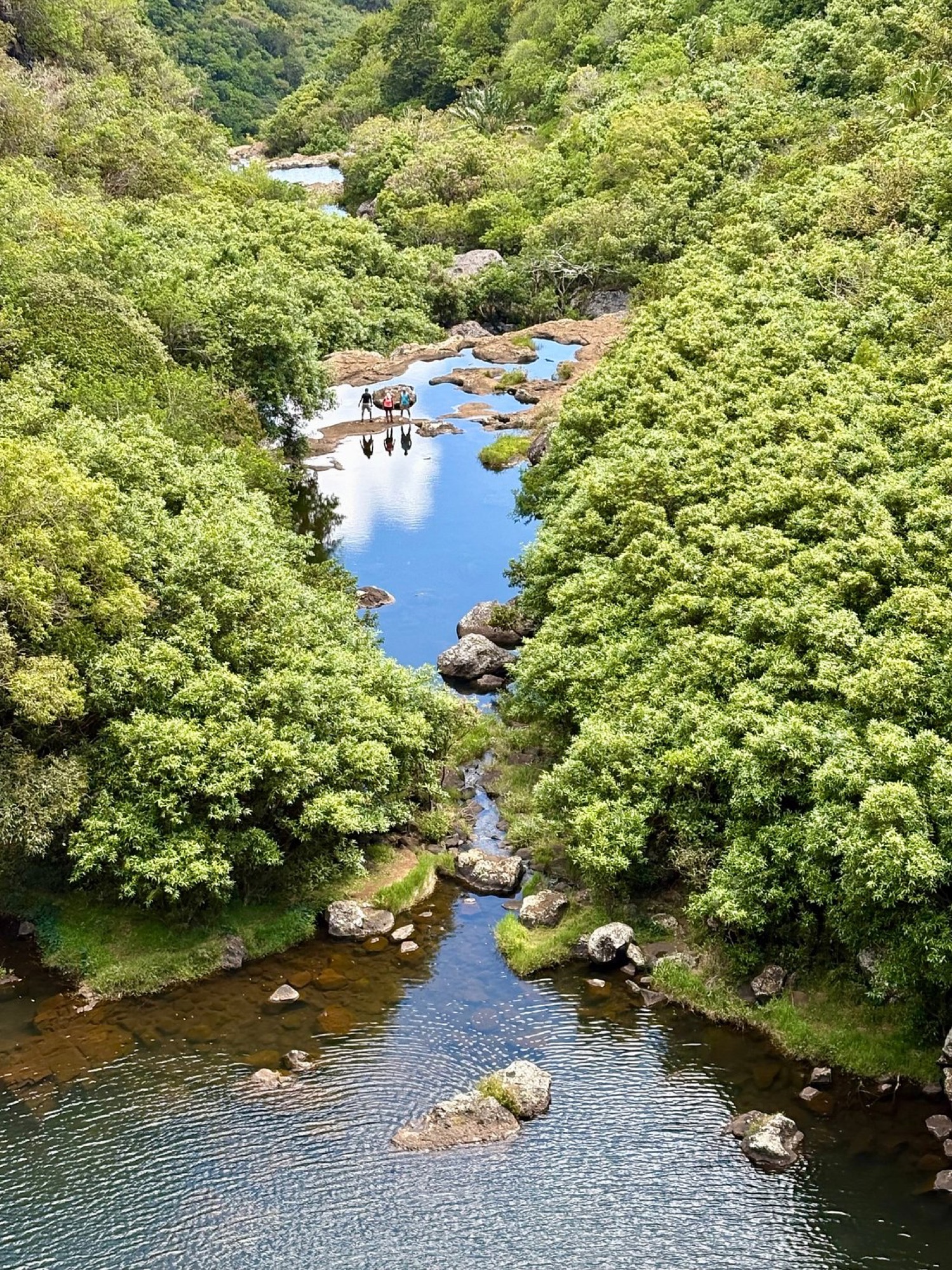 Hikers at the reflective upper pools of Tamarind Falls (7 Cascades), Mauritius